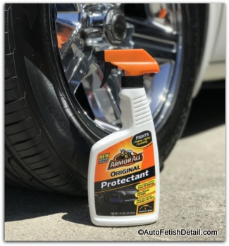 bottle of Armor original protectant sitting on ground next to a chrome wheel Armor all original protectant on tire