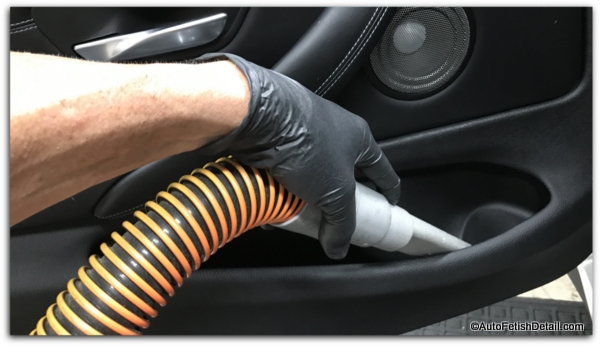 cleaning vacuuming car interior of BMW with black interior and leather cleaning vacuuming car interior