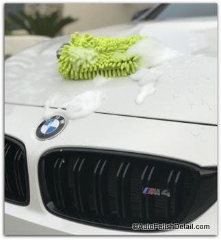 chenille wash mitt on top of hood of white BMW M4 Mr Clean car washing kit alternative
