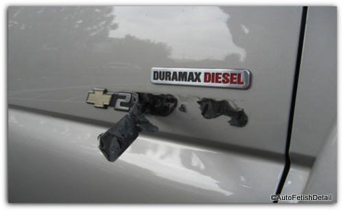 truck emblem removal showing the emblem and the double sided tape underneath truck emblem removal