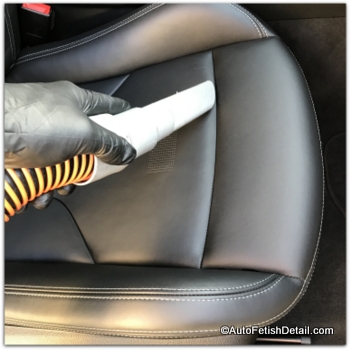 vacuuming black car leather in BMW M4 before cleaning car vacuuming car leather before cleaning car